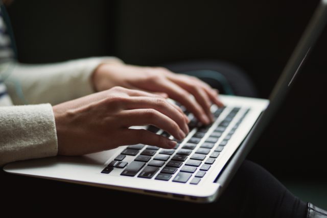 Tangenbord på en laptop och händer som skriver