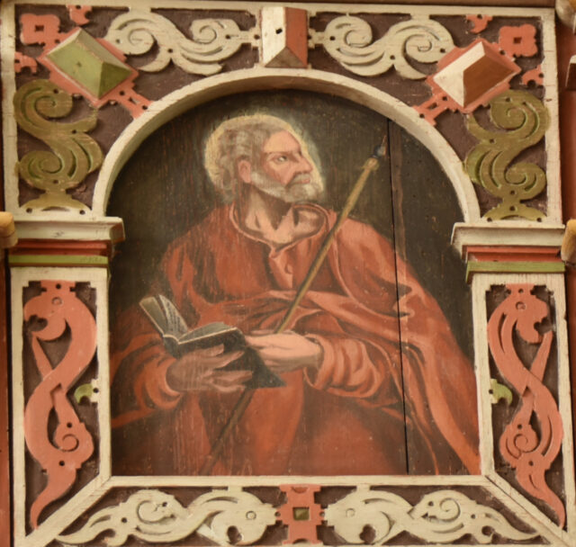 En ålderdomlig målning på trä av en man i röd mantel som håller i en spira och en bok. 